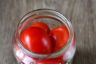 tightly fill the jars with tomatoes