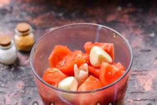 letakkan tomato dan bawang putih dalam mangkuk pengisar