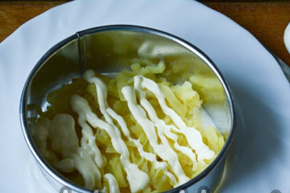vet een laag geraspte aardappelen in met mayonaise
