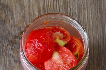 поставете доматите в бурканите